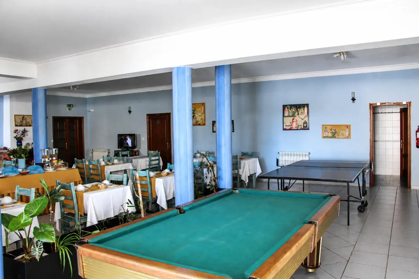 Sala de jogos com mesa de bilhar e ténis de mesa junto à sala de refeições