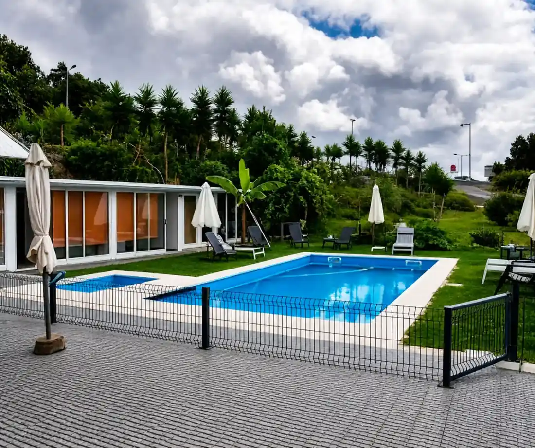 Piscina exterior sazonal com relva, espreguiçadeiras e chapéus de sol à luz do dia